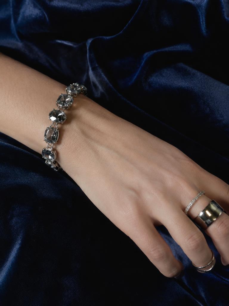 Crystal bracelet and silver rings on midnight-blue velvet